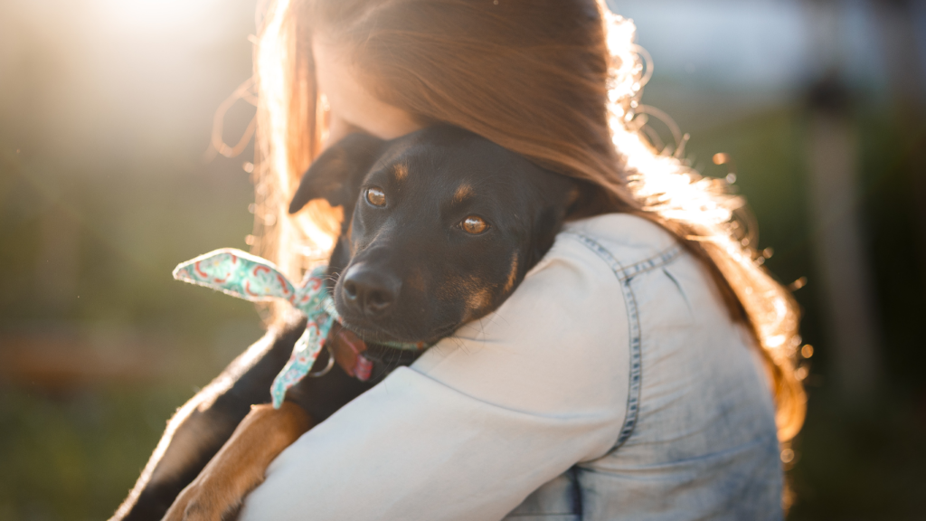 A joyful rescue dog with a wagging tail and bright eyes, happily sitting beside their new owner, showcasing the strong bond and companionship formed through adoption.